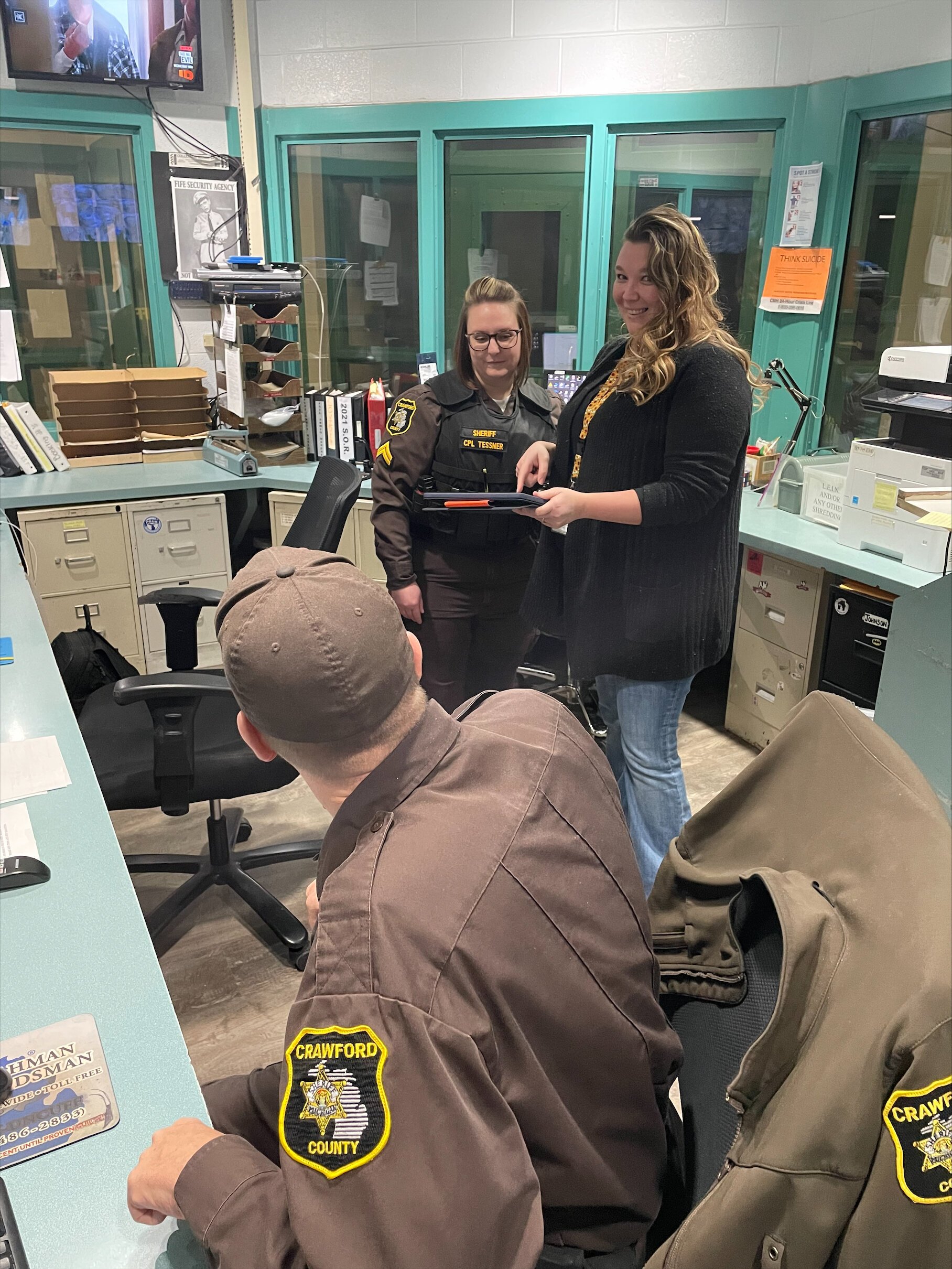 NLCMHA Crisis Therapist Amanda Clements shares tips on using the tablet to dispatch the mobile crisis team with C.O. Dale Suiter and Cpl. Katie Tessner.
