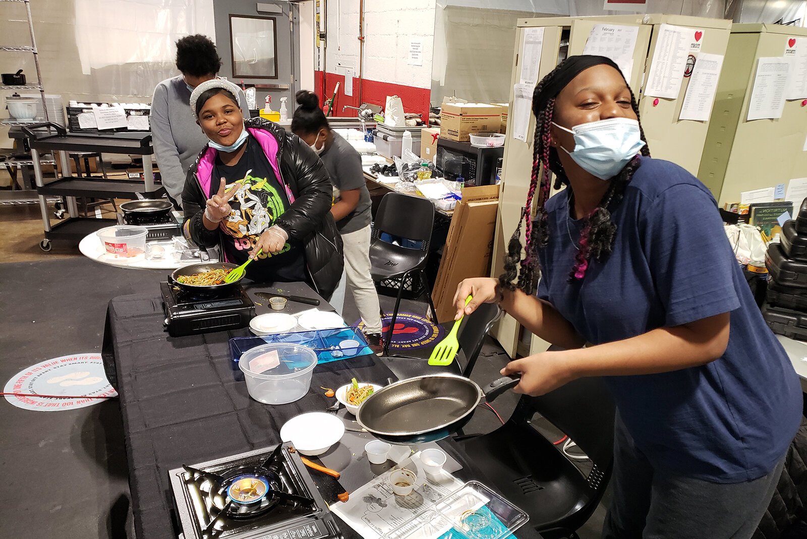 Participants cook food during a session of The Learning Kitchen.