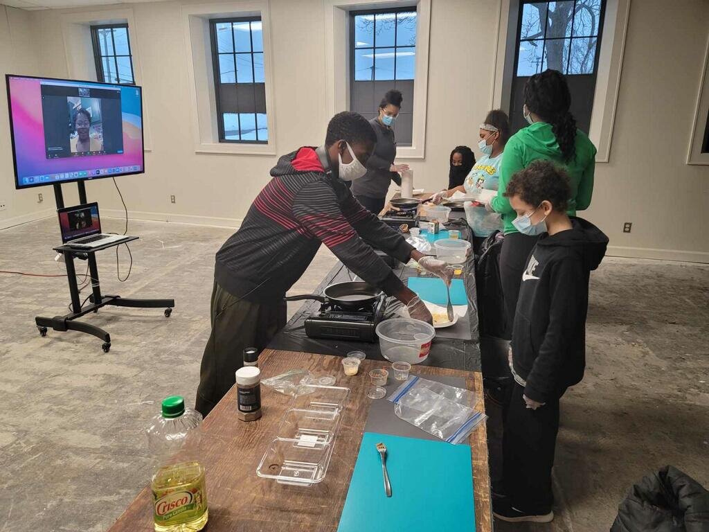 Participants cook food during a session of The Learning Kitchen.