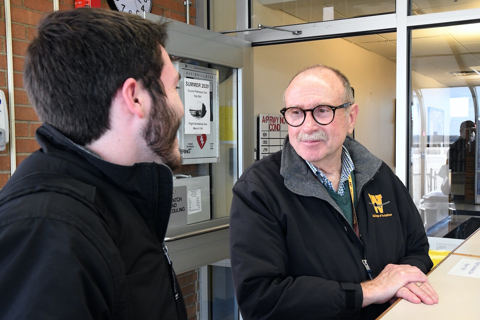 Dave Powell, dean of Western Michigan University’s College of Aviation, right, talks with William Gaffney, a graduate and instructor.