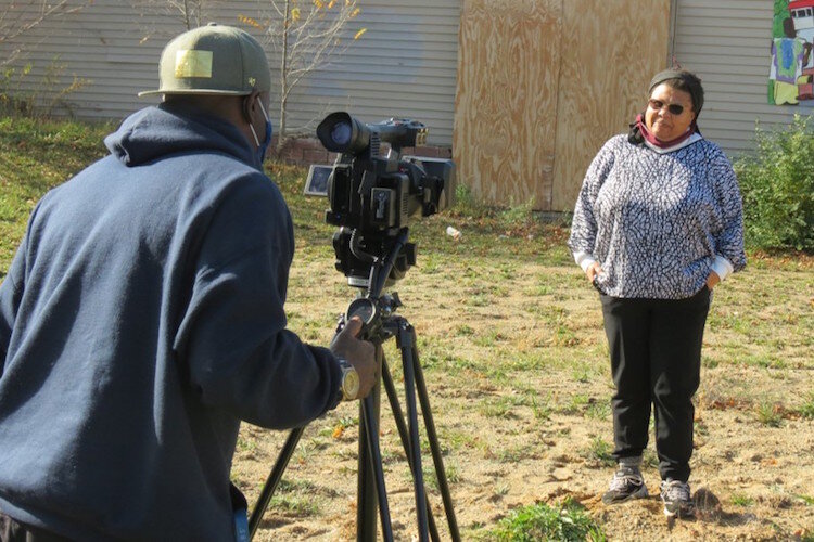 Pat Taylor, director of the Kalamazoo Eastside Neighborhood Association, is filmed by Gerald King at the 1616 E. Main St. site where Eastside Sunrise Plaza will be developed. Supported by Public Media Network, King is filming a short documentary.