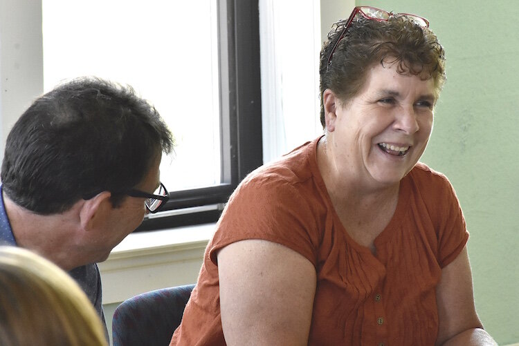 Kathy Gross, an independent consultant, laughs while accepting a talking stone during an A2A meeting.