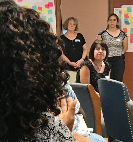 During the Wednesday, July 10, 2019, visioning session for the 1600 block of East Main Street, professionals listen to ideas from Twala Lockett-Jones, foreground. In the background: standing at left is Sandy Bliesener, of O'Boyle, Cowell, Blalock & Associates; standing at right is Hannah Knoll, of InForm Architecture; and seated in the middle is Kelly Clarke, of the Kalamazoo County Land Bank.