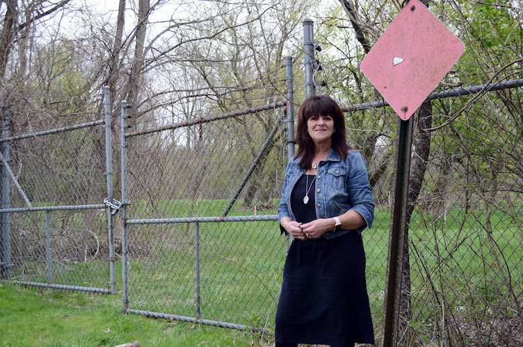 Galesburg mayor Lori West at the end of Mill Street. For the Kalamazoo River Valley Trail length through Galesburg, the gates will come down and the trail will meander through the trees along the Kalamazoo River.