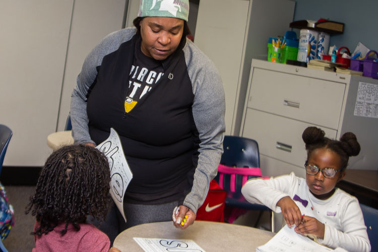 Classroom coach Ms. Jewel works with kindergarten and first graders in the New Genesis after school program.