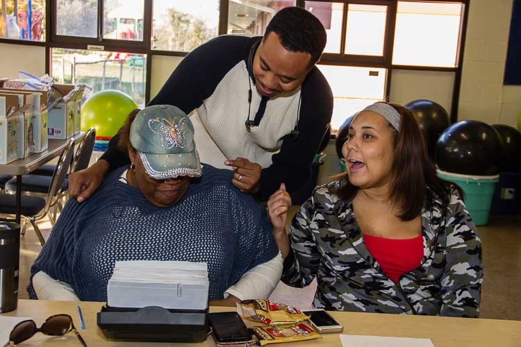 Denise Rucker, Dr. Mike Glass, and Aliyah work together during a recent diaper disribution at Parkway Manor. Photo by Susan Andress.