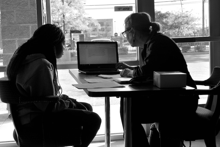 Ke'Asia Shepherd-Friday and Theresa Coty O'Neil review a writing guide together. Photo by Vicky Kettner