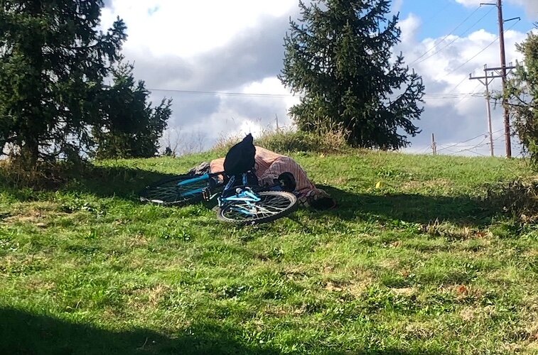An unhoused man seems to find his own green space in the heart of downtown Kalamazoo.