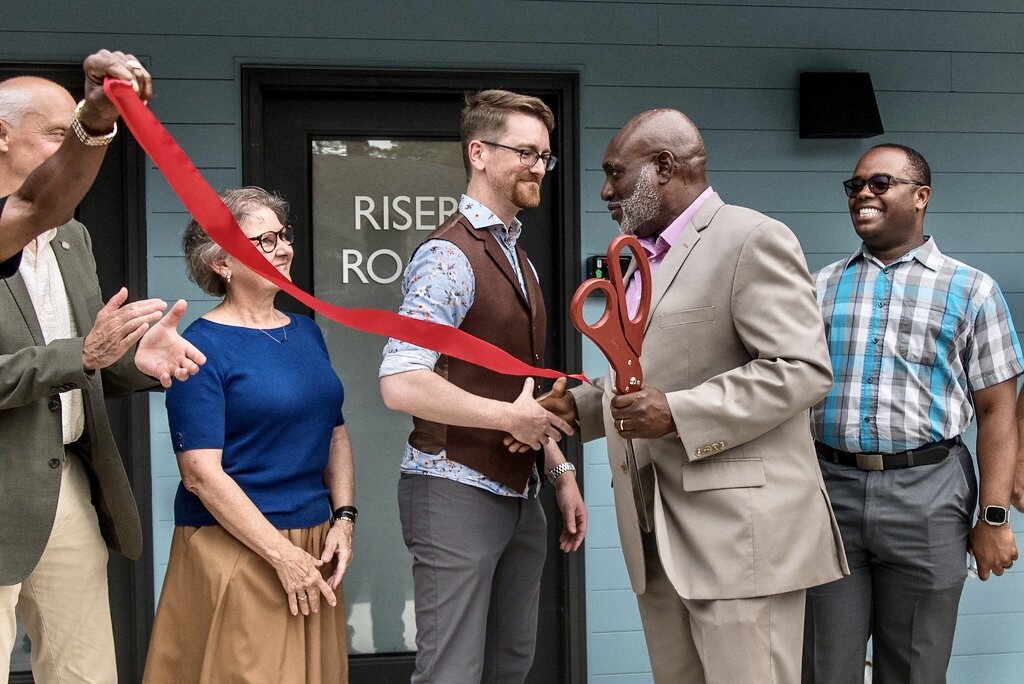 Sydney Ellis, of the Kalamazoo County Land Bank, shakes hands on Tuesday, June 25, 2024 with Land Bank Chairman Thomas Whitener at the ribbon-cutting ceremony for the Eastside Square Condominiums.