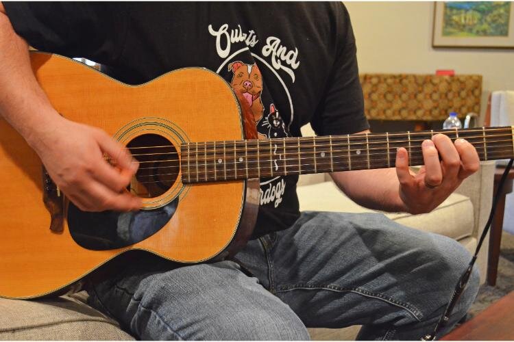 Cory Johnson plays his guitar for the group during the beginning of the meeting.