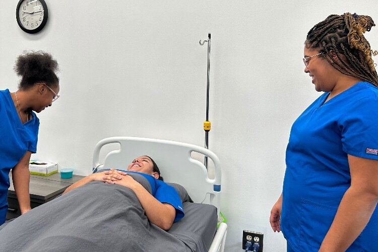 Acasia Pippin train with classmate Acurea Brown in the bed, as Diamond “DeDe” Davis watches.