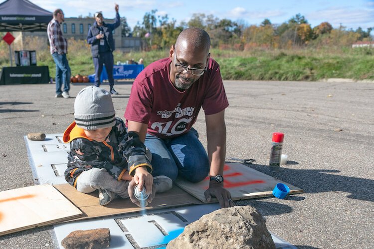Michael Evans, Kalamazoo Exec. Dir. of the Kalamazoo Literacy Council, helps prepare signs for the trail
