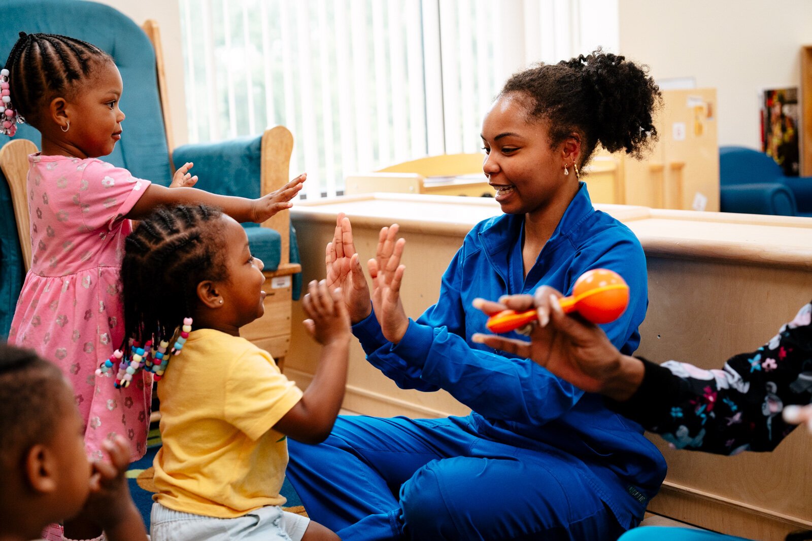 Teacher Kiaundra Bronson plays patty-cake with a student at New St. Paul Head Start Agency in Detroit.
