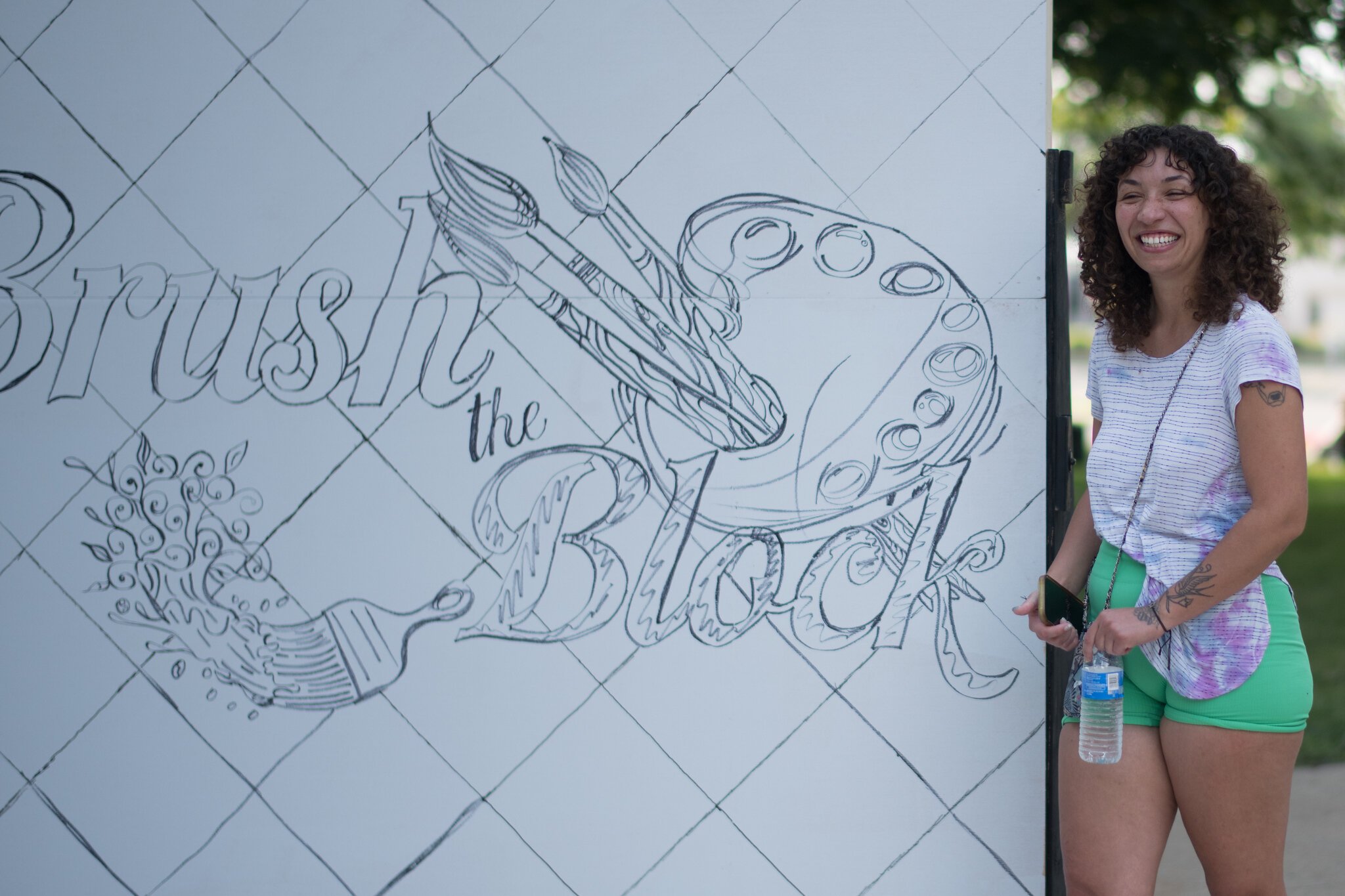 Artist Maya James celebrates having been chosen to paint a mural on the side of the Kalamazoo Transit Building.