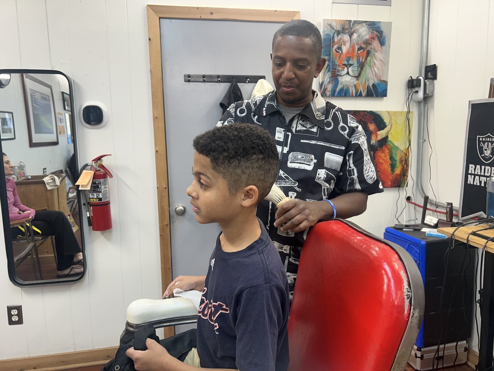 David Lehman-Oliver, 9, gets his haircut by his longtime barber Jerome Lenzy at Rob’s Barber Shop during a Barbershop and Literacy event in the Vine Neighborhood.