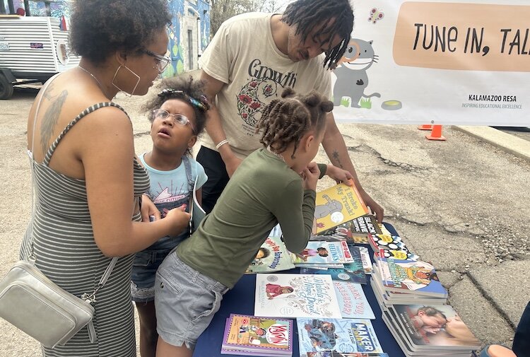A Kalamazoo family looks at the free books available at a Barbershop and Literacy event in the Vine Neighborhood.