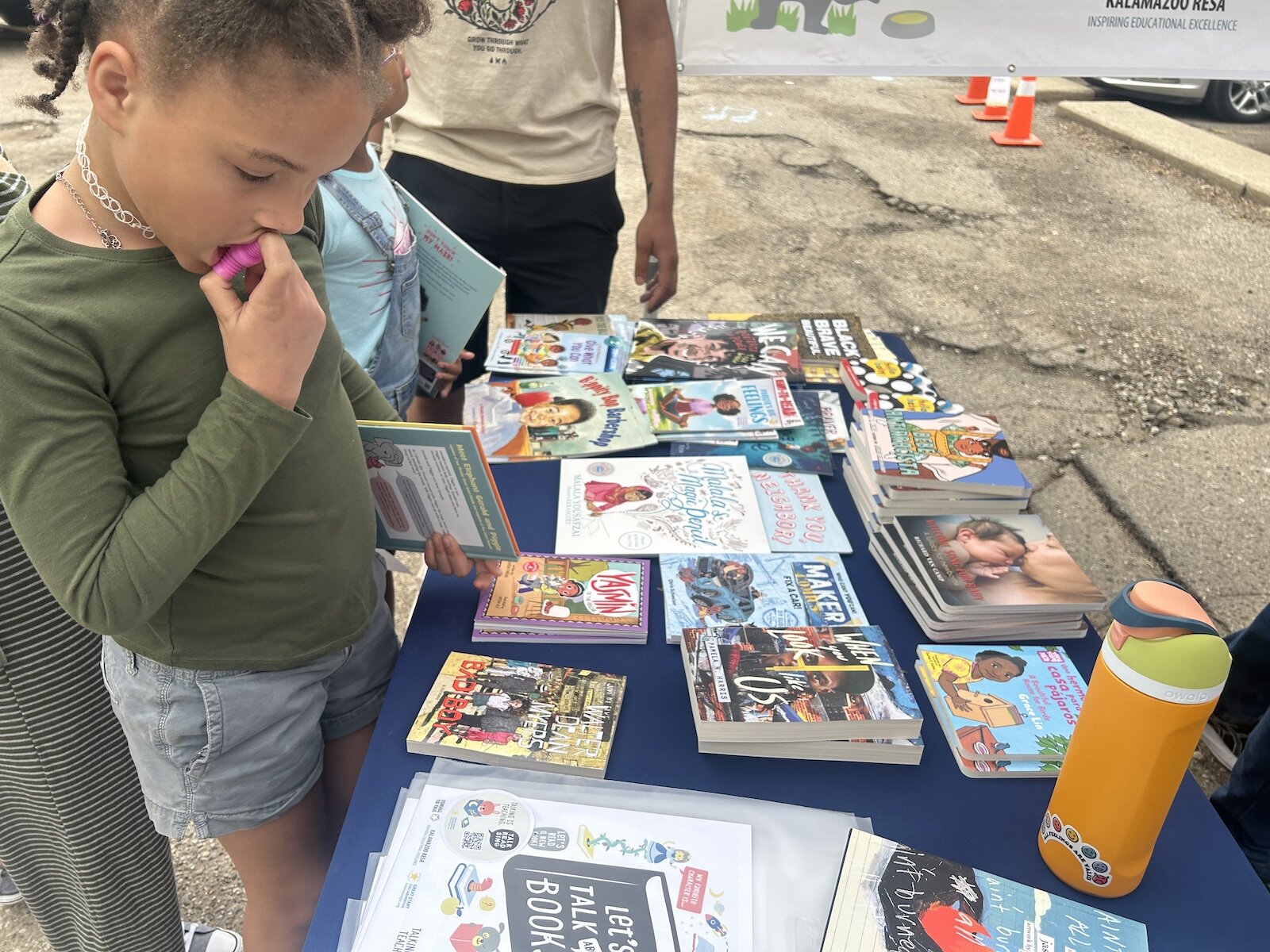 Decision, decisions. A young girl looks at the free books available during a recent Barbershop and Literacy event in the Vine Neighborhood.