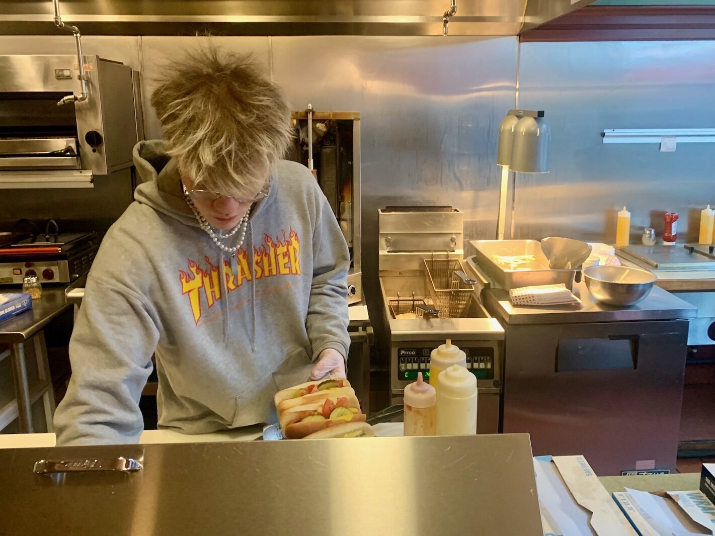 Bryson Merriam prepares hot dogs inside Coney Island Kalamazoo hot dog restaurant in downtown Kalamazoo.