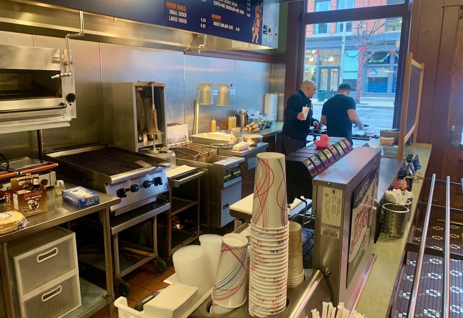 Mike Adams, shown at right cooking inside his Coney Island Kalamazoo hot dog restaurant, says he looks forward to having more residents in downtown Kalamazoo.