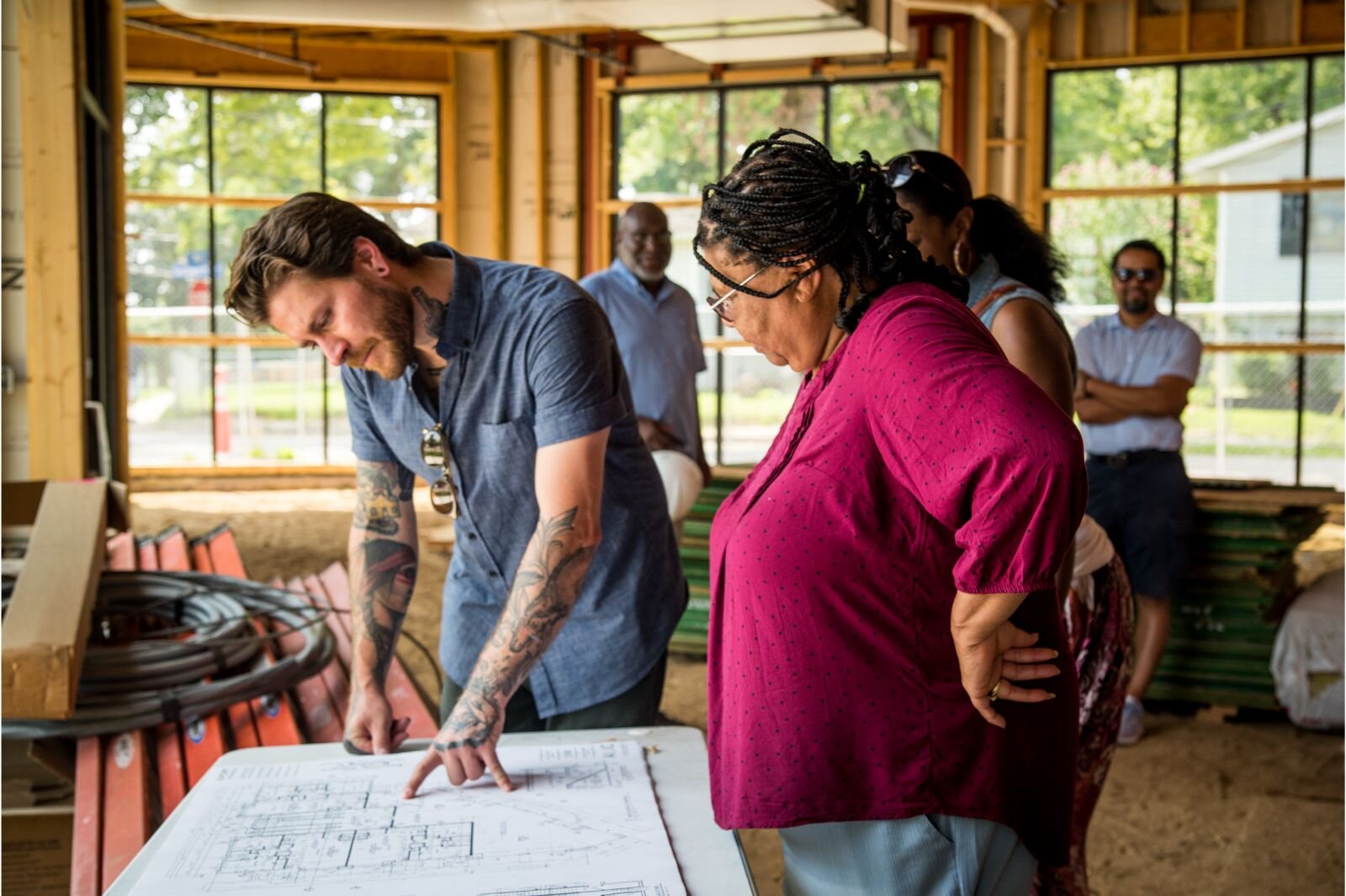 Pat Taylor, executive director of the Kalamazoo Eastside Neighborhood Association, at right, studies plans for the 1601 East Main St. development.