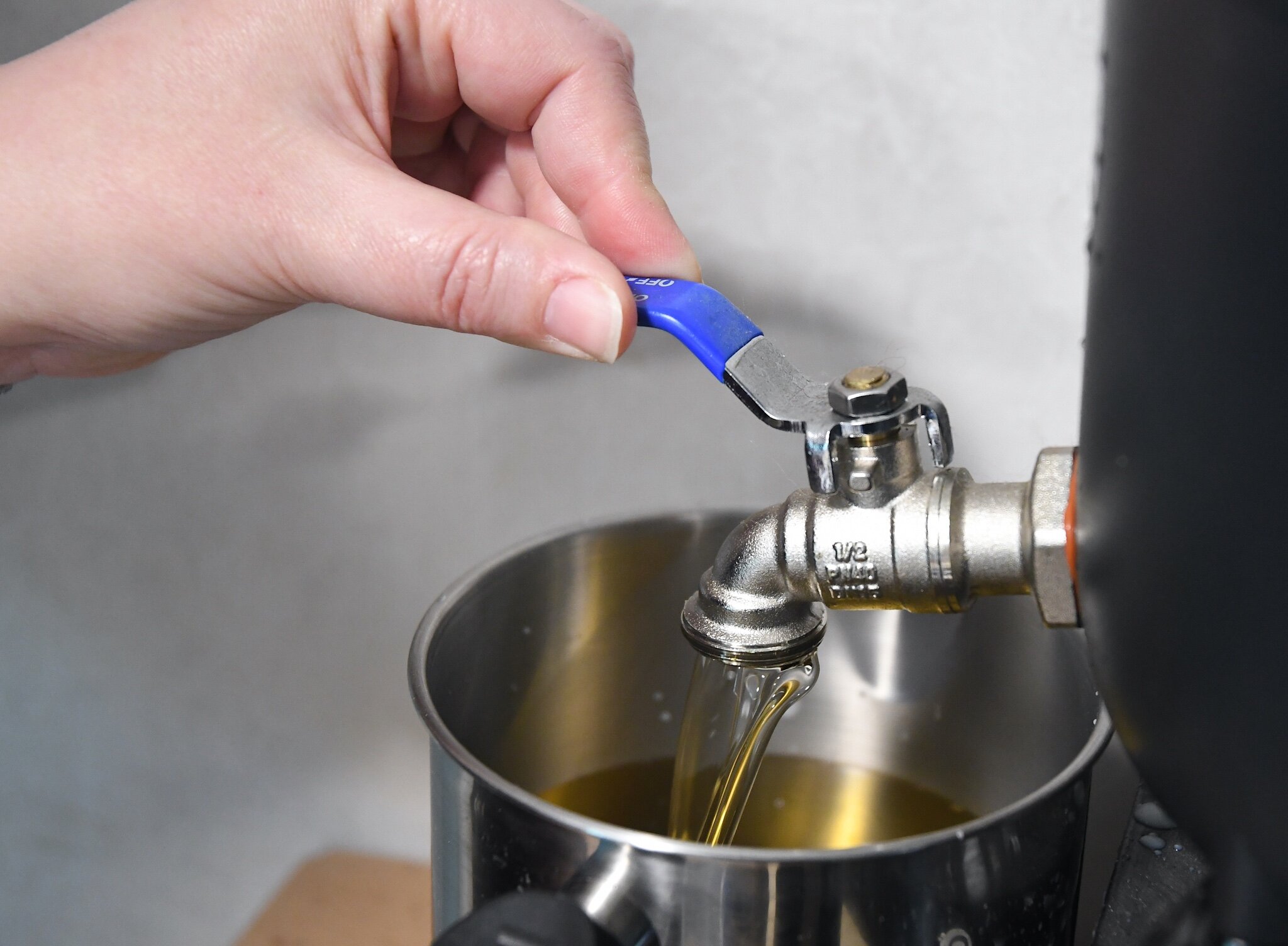 Kellee VanValkenburg adds scent to melted soy wax in a container.