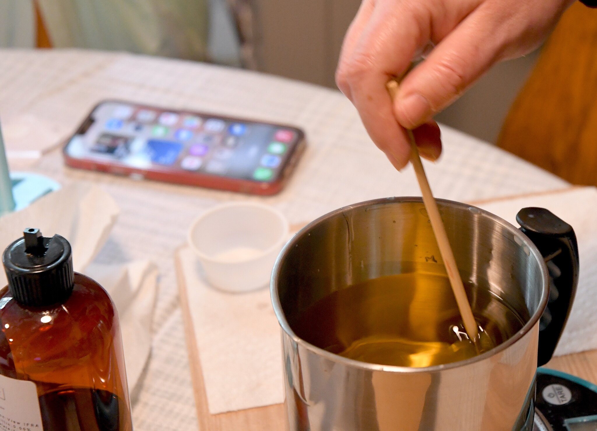 Kellee VanValkenburg stirs melted wax after the scent is added.