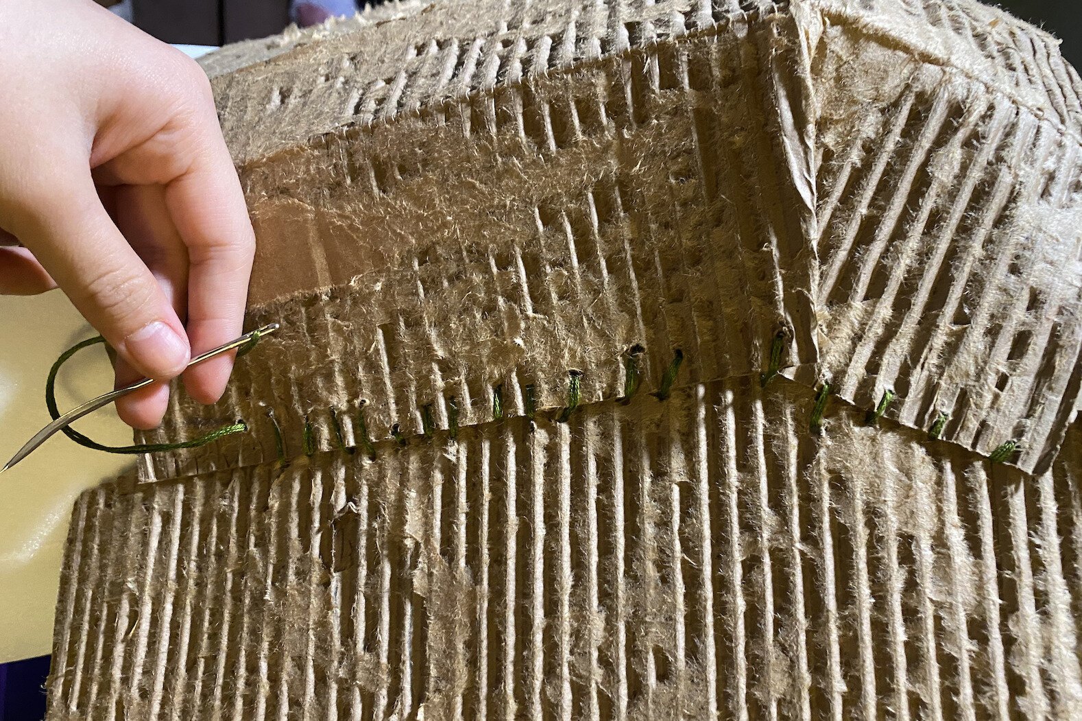 On the mannequin, the cardboard was shaped into the top portion of the dress. It was then sewn together with embroidery floss.