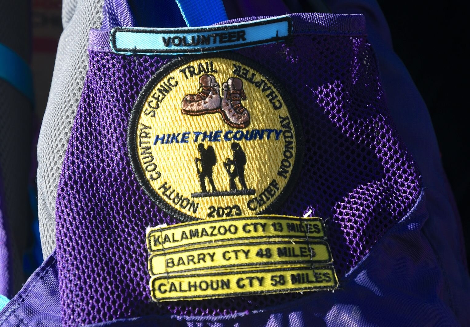 Some of the patches that Jane Norton has collected are on her backpack.
