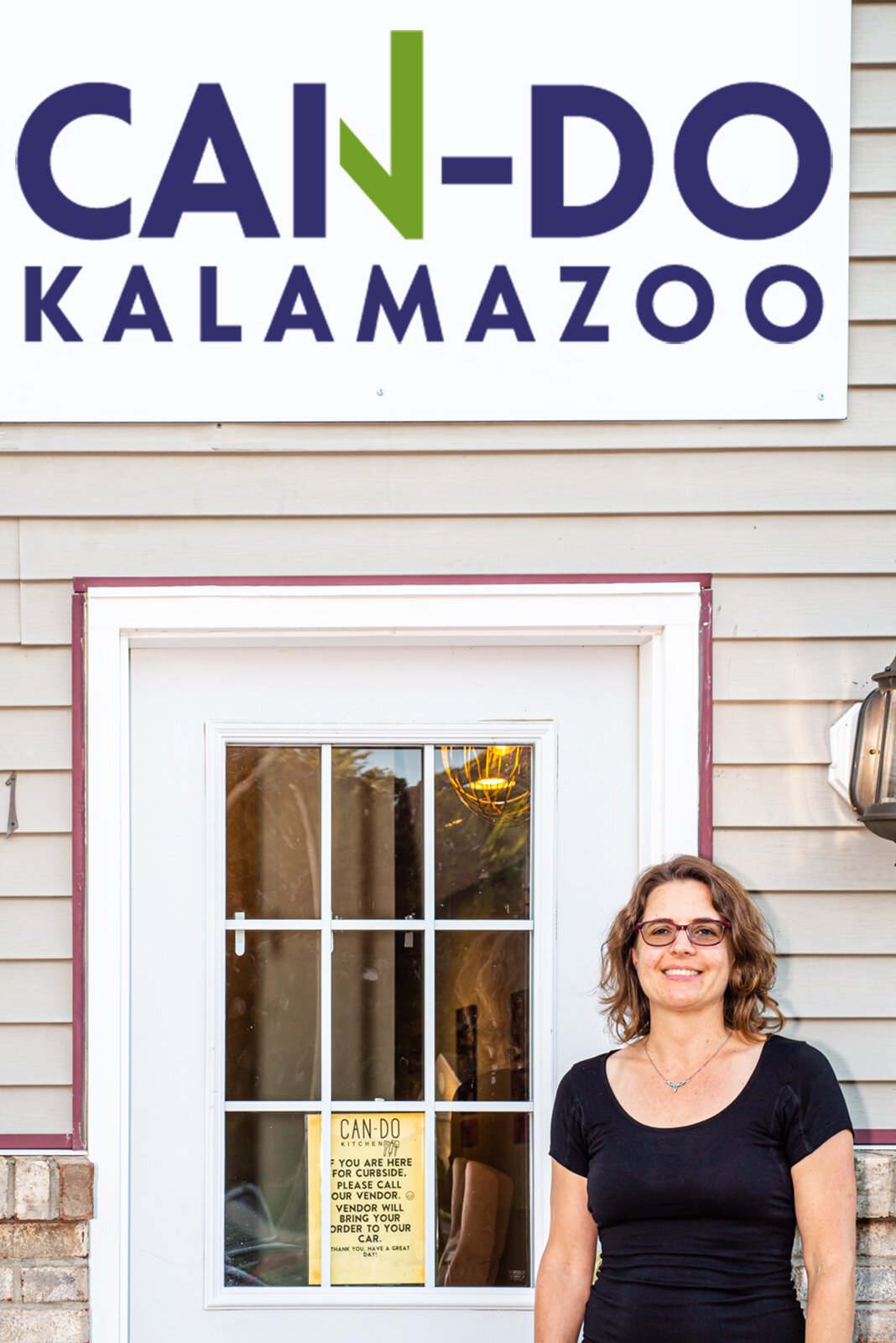 In front of the Can Do Kalamazoo Building is Executive Director Lucy Dilley.