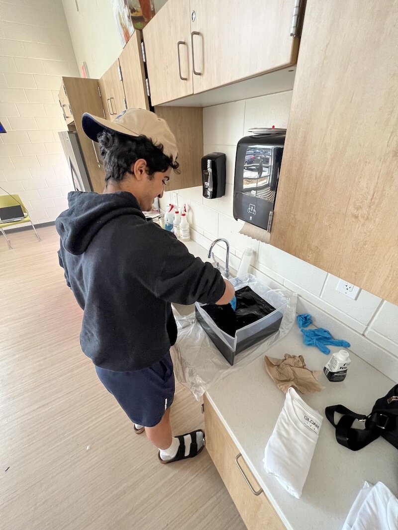 Mahdi Hassnawi dyes a T-Shirt for his Voices of Youth art project .