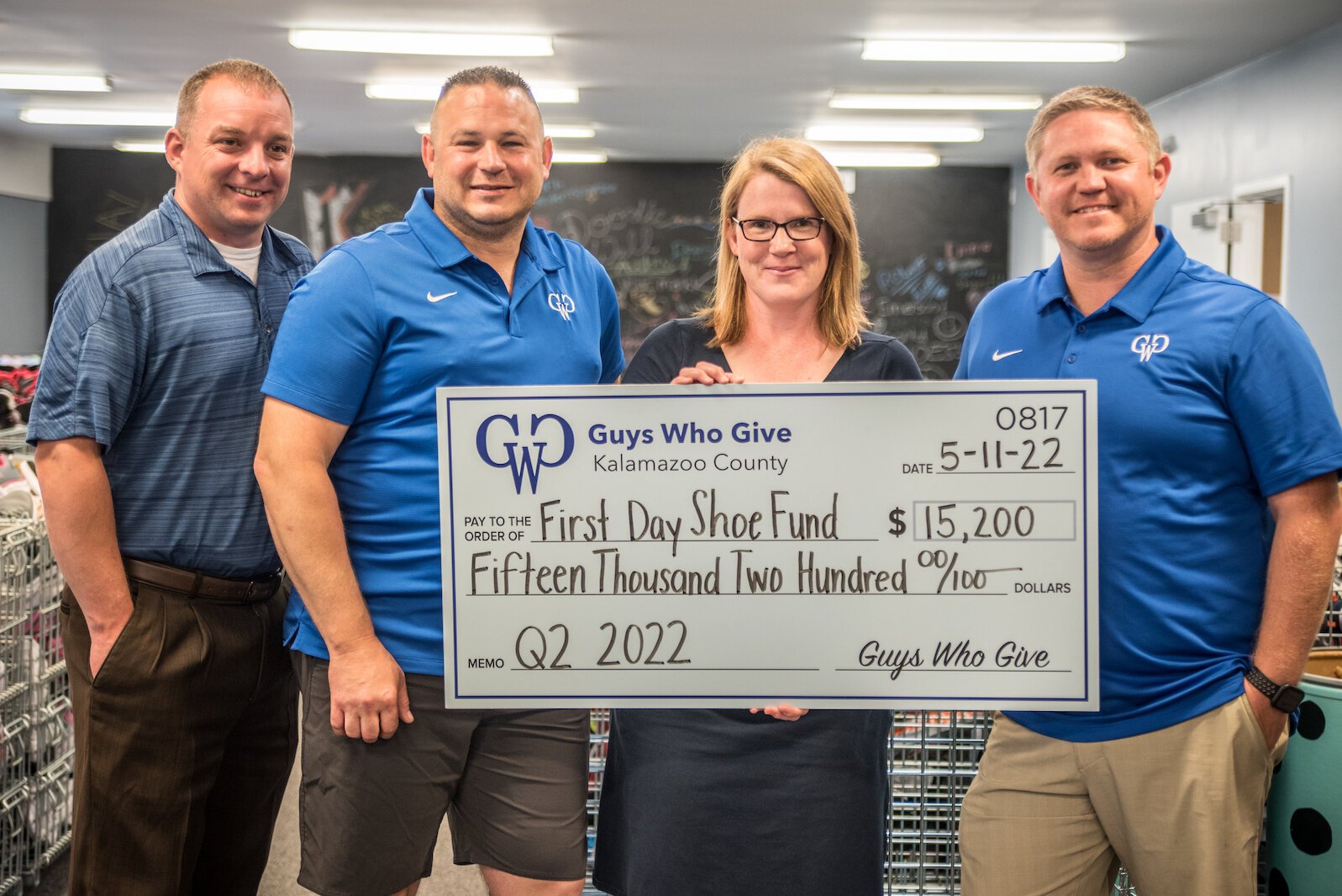 Maggie Hesketh, executive director of First Day Shoe Fund, receives a major gift on Wednesday, June 22, 2022, from members of Guys Who Give. From left, they are Tim Evans, Don Solesbee, and Cody Livingston.