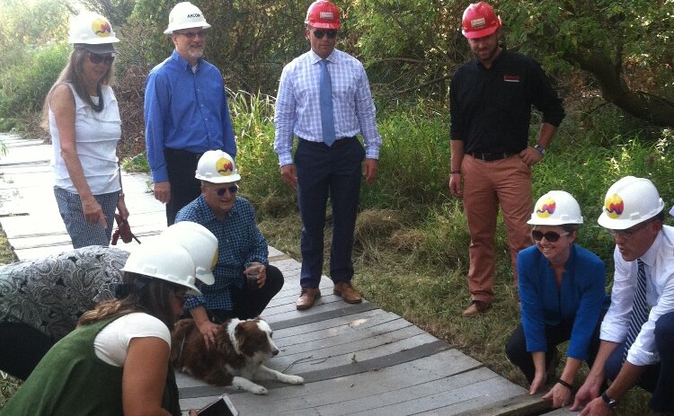 At the 2017 groundbreaking for Huff Park improvements, David Marquardt and other guests remove sections of the old boardwalk.