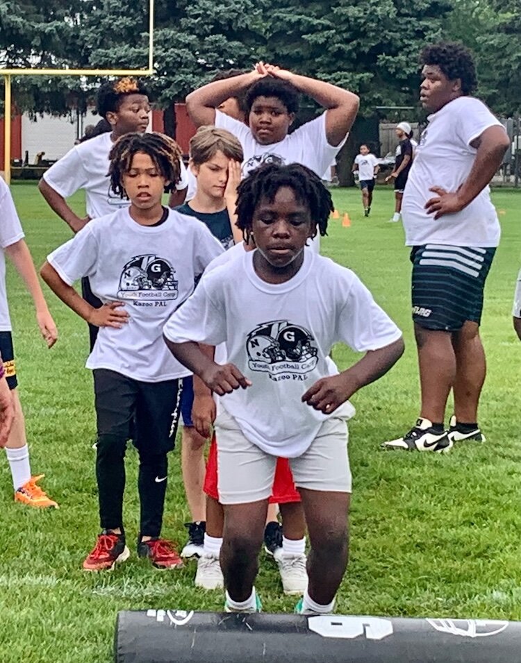 A young football player gets serious about clearing obstacles in one of several drills on at the Kalamazoo Youth Football Camp, held Saturday, Aug. 26, 2025 at Mayor’s Riverfront Park.